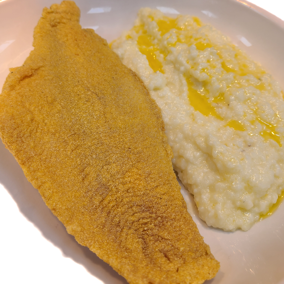 Golden breaded fish served with buttery grits.
